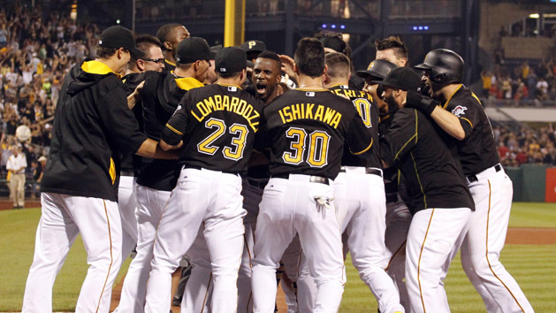 Jul 11, 2015; Pittsburgh, PA, USA; Pittsburgh Pirates center fielder Andrew McCutchen (center facing) is mobbed at home after hitting a game winning two run home run against the St. Louis Cardinals during the fourteenth inning at PNC Park. The Pirates won 6-5 in fourteen innings. Mandatory Credit: Charles LeClaire-USA TODAY Sports