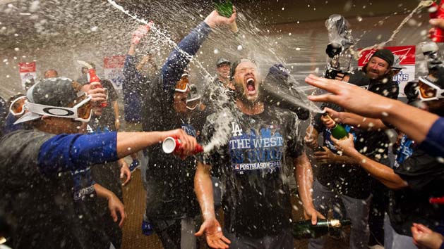 Sep 29, 2015; San Francisco, CA, USA; Los Angeles Dodgers teammates spray champagne and beer on starting pitcher Clayton Kershaw (22) in the locker room after clinching the NL west after a win against the San Francisco Giants at AT&T Park.The Los Angeles Dodgers defeated the San Francisco Giants 8-0. Mandatory Credit: Kelley L Cox-USA TODAY Sports