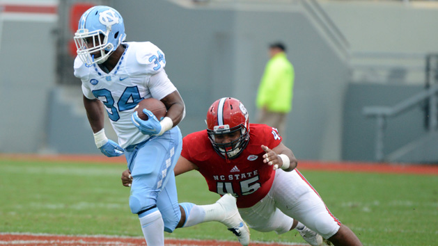 Nov 28, 2015; Raleigh, NC, USA; North Carolina Tar Heels running back Elijah Hood (34) runs the ball as North Carolina State Wolfpack defensive end Darian Roseboro (45) defends during the first half at Carter Finley Stadium. Mandatory Credit: Rob Kinnan-USA TODAY Sports