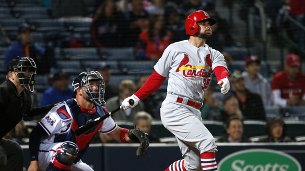 Apr 8, 2016; Atlanta, GA, USA; St. Louis Cardinals second baseman Greg Garcia (35) hits a solo home run as Atlanta Braves catcher Tyler Flowers (25) looks on in the ninth inning of their game at Turner Field. The Cardinals won 7-4. Mandatory Credit: Jason Getz-USA TODAY Sports