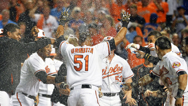 Aug 19, 2015; Baltimore, MD, USA; Baltimore Orioles celebrate at home plate after left fielder Henry Urrutia (51) hit a walk off home run during the ninth inning against the New York Mets at Oriole Park at Camden Yards. Baltimore Orioles defeated New York Mets 5-4. Mandatory Credit: Tommy Gilligan-USA TODAY Sports