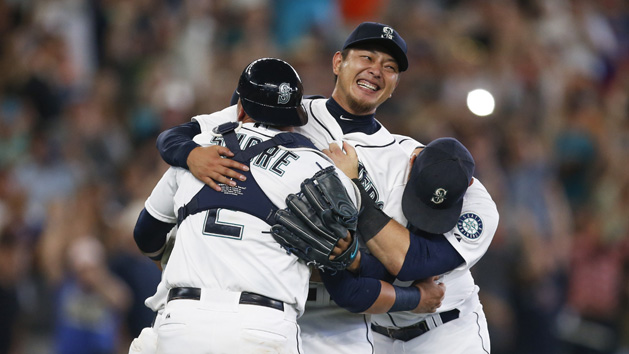 Aug 12, 2015; Seattle, WA, USA; Seattle Mariners pitcher Hisashi Iwakuma (18, center) celebrates with his teammates following the final out of his no-hit, 3-0 victory against the Baltimore Orioles at Safeco Field. Mandatory Credit: Joe Nicholson-USA TODAY Sports