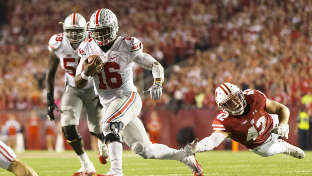 Oct 15, 2016; Madison, WI, USA; Ohio State Buckeyes quarterback J.T. Barrett (16) rushes with the football as Wisconsin Badgers linebacker T.J. Watt (42) dives from behind during the fourth quarter at Camp Randall Stadium. Ohio State won 30-23. Photo Credit: Jeff Hanisch-USA TODAY Sports
