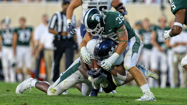 Aug 31, 2018; East Lansing, MI, USA; Utah State Aggies running back Darwin Thompson (5) is tackled by Michigan State Spartans linebacker Joe Bachie (35) during the first quarter of a game at Spartan Stadium. Photo Credit: Mike Carter-USA TODAY Sports