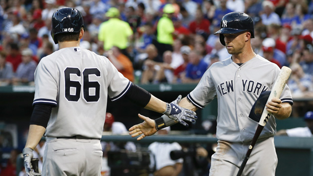 Jul 28, 2015; Arlington, TX, USA; New York Yankees left fielder Brett Gardner (R) is congratulated by catcher John Ryan Murphy (66) after scoring a run against the Texas Rangers during the second inning of a baseball game at Globe Life Park in Arlington. Mandatory Credit: Jim Cowsert-USA TODAY Sports