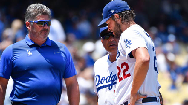 Jul 23, 2017; Los Angeles, CA, USA; Los Angeles Dodgers starting pitcher Clayton Kershaw (22) talks to manager Dave Roberts (center) and trainer Nate Lucero after injuring himself in the second inning against the Atlanta Braves at Dodger Stadium. After throwing a few warmup pitches Kershaw stayed in the game but was pulled in the next inning. Photo Credit: Robert Hanashiro-USA TODAY Sports