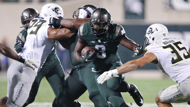 Sep 12, 2015; East Lansing, MI, USA; Michigan State Spartans running back LJ Scott (3) stiff arms Oregon Ducks linebacker Joe Walker (35) during a touchdown run in the fourth quarter at Spartan Stadium. Spartans beat the Ducks 31-28. Mandatory Credit: Raj Mehta-USA TODAY Sports