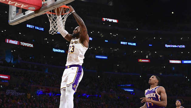 Dec 2, 2018; Los Angeles, CA, USA; Los Angeles Lakers forward LeBron James (23) slam dunks in the third quarter against the Phoenix Suns at Staples Center.Right is Phoenix Suns guard De'Anthony Melton (14). Photo Credit: Robert Hanashiro-USA TODAY Sports