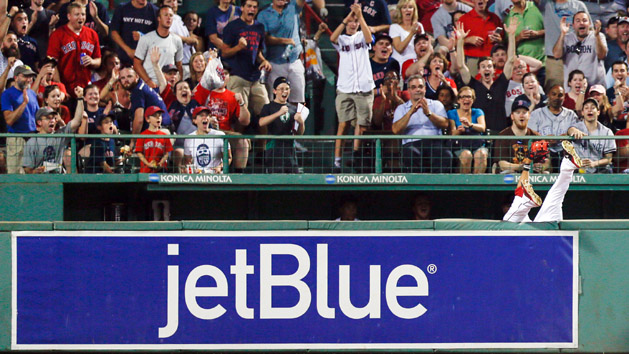 Jul 28, 2015; Boston, MA, USA; Boston Red Sox center fielder Mookie Betts (50) goes over the right field wall to catch a fly ball hit by Chicago White Sox first baseman Jose Abreu (not pictured). The call was overturned and Abreu was granted a two-run home run during the sixth inning at Fenway Park. Mandatory Credit: Greg M. Cooper-USA TODAY Sports