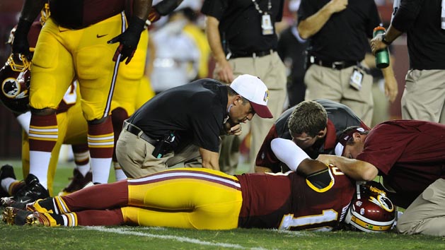Robert Griffin III (10) is looked at by trainers after suffering an injury against the Detroit Lions during the first half at FedEx Field. (Brad Mills-USA TODAY) Sports