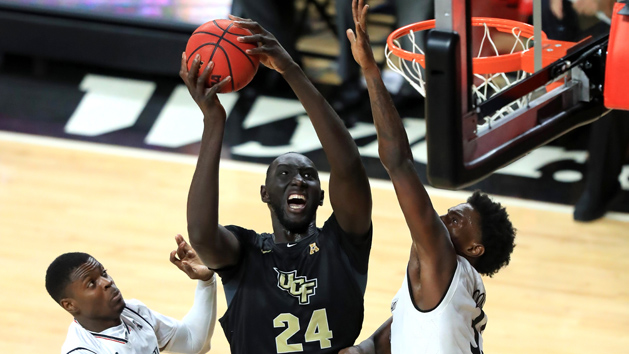 Feb 21, 2019; Cincinnati, OH, USA; UCF Knights center Tacko Fall (24) drives to the basket against Cincinnati Bearcats center Nysier Brooks (33) and forward Trevon Scott (13) in the second half at Fifth Third Arena. Photo Credit: Aaron Doster-USA TODAY Sports