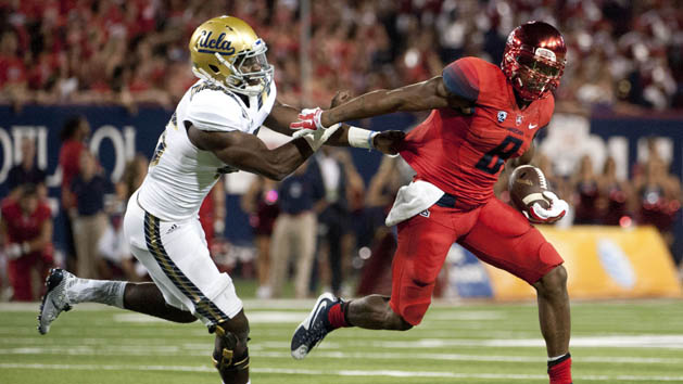 Sep 26, 2015; Tucson, AZ, USA; Arizona Wildcats quarterback Jerrard Randall (8) runs the ball under pressure from UCLA Bruins linebacker Kene Orjioke (46) during the third quarter at Arizona Stadium. UCLA won 56-30. Mandatory Credit: Casey Sapio-USA TODAY Sports