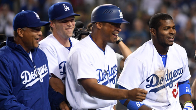 Jun 22, 2016; Los Angeles, CA, USA; Los Angeles Dodgers right fielder Yasiel Puig (66) celebrates manager Dave Roberts (left) and third base coach George Lombard (center) after scoring against the Washington Nationals on an error after a single in the ninth inning at Dodger Stadium. The Dodgers defeated the Nationals 4-2. Photo Credit: Kirby Lee-USA TODAY Sports